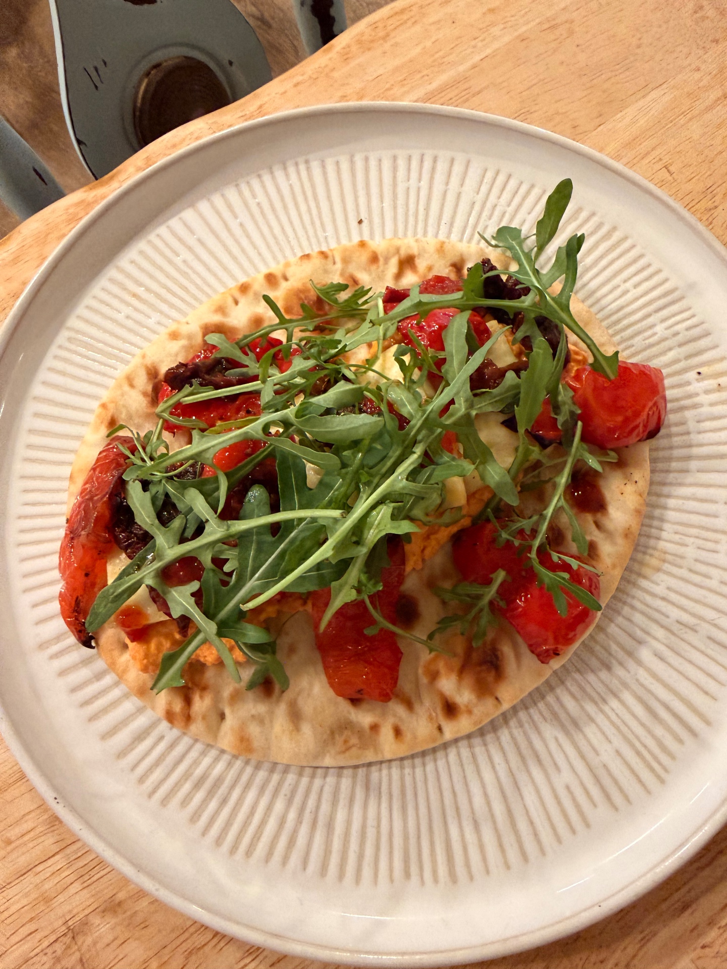 Flatbread topped with roasted peppers and rocket