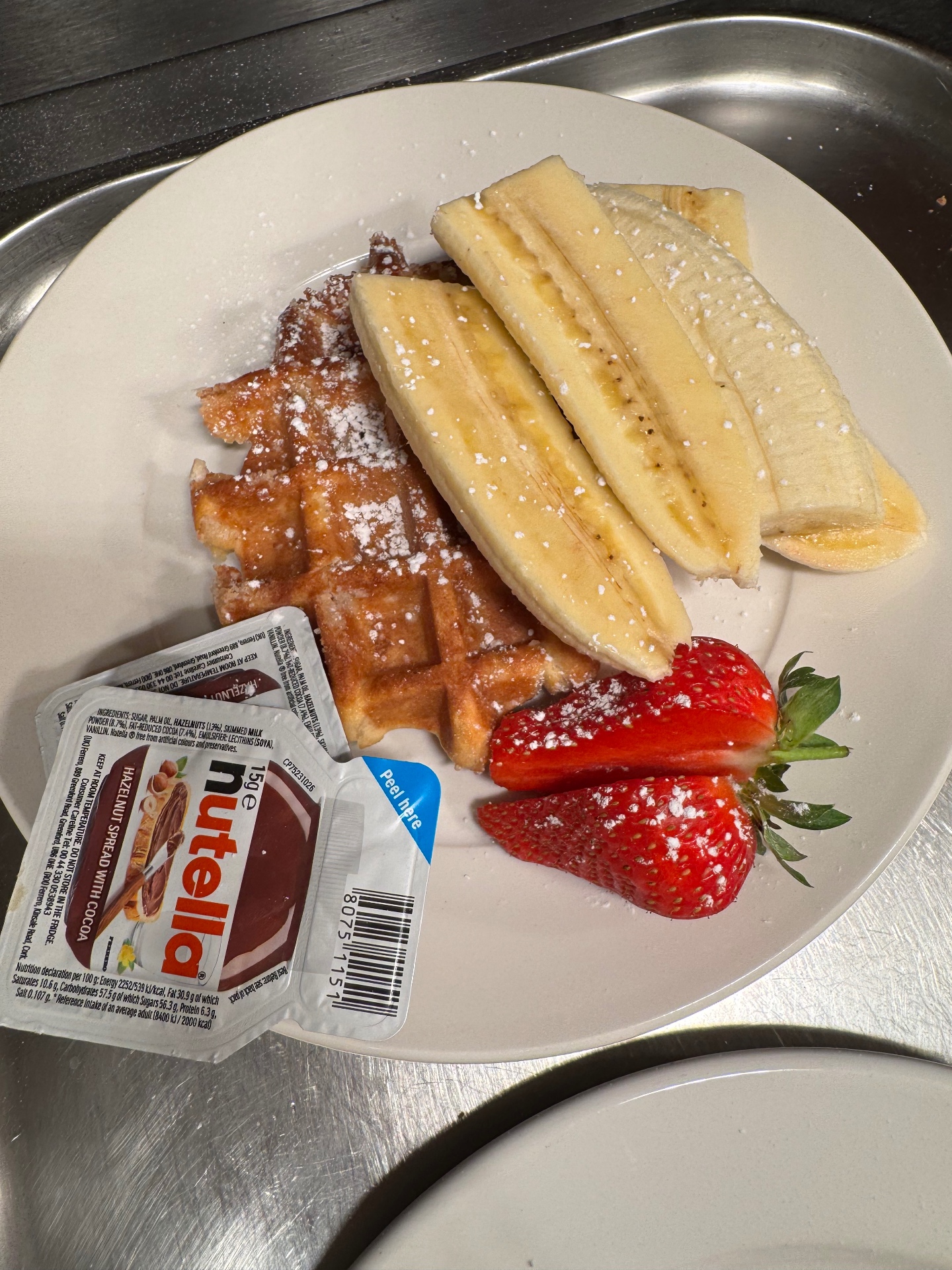 Waffle topped with banana and served with strawberries